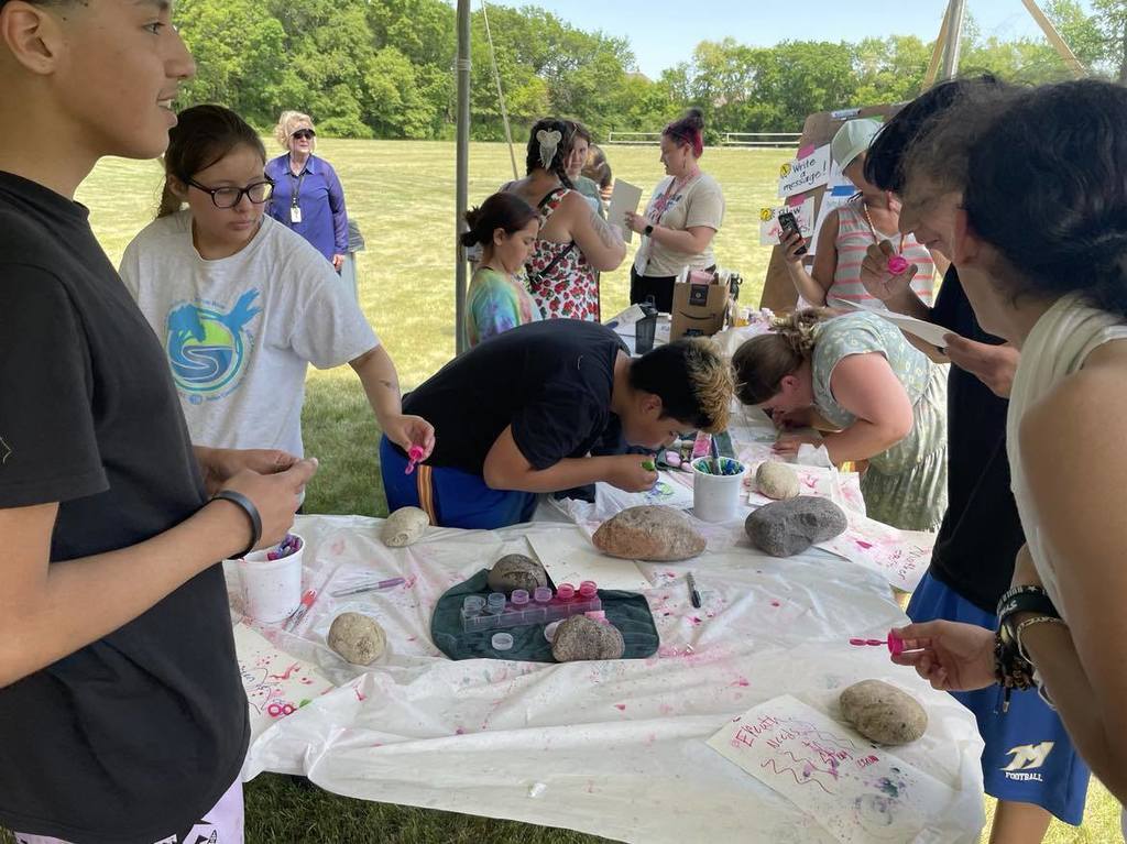 Students blowing bubbles on their artwork for Mother Earth.