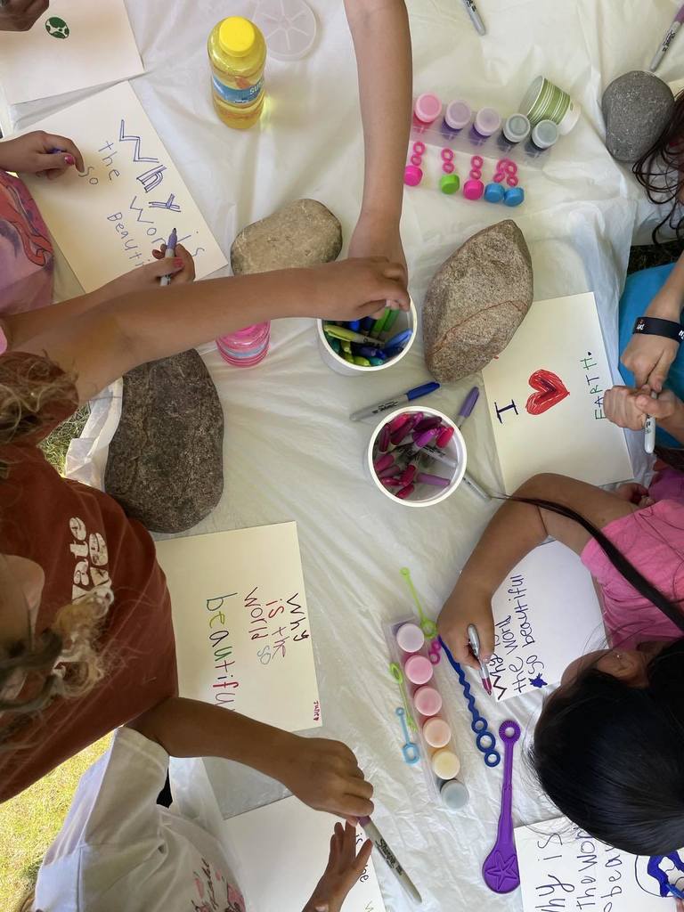 Students painting outside with bubble colors to celebrate Mother Earth.