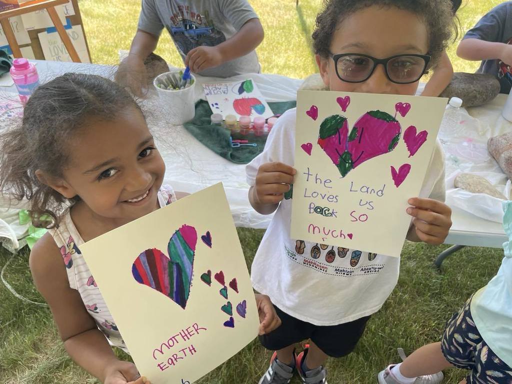 Students showing their "we love mother earth" artwork.