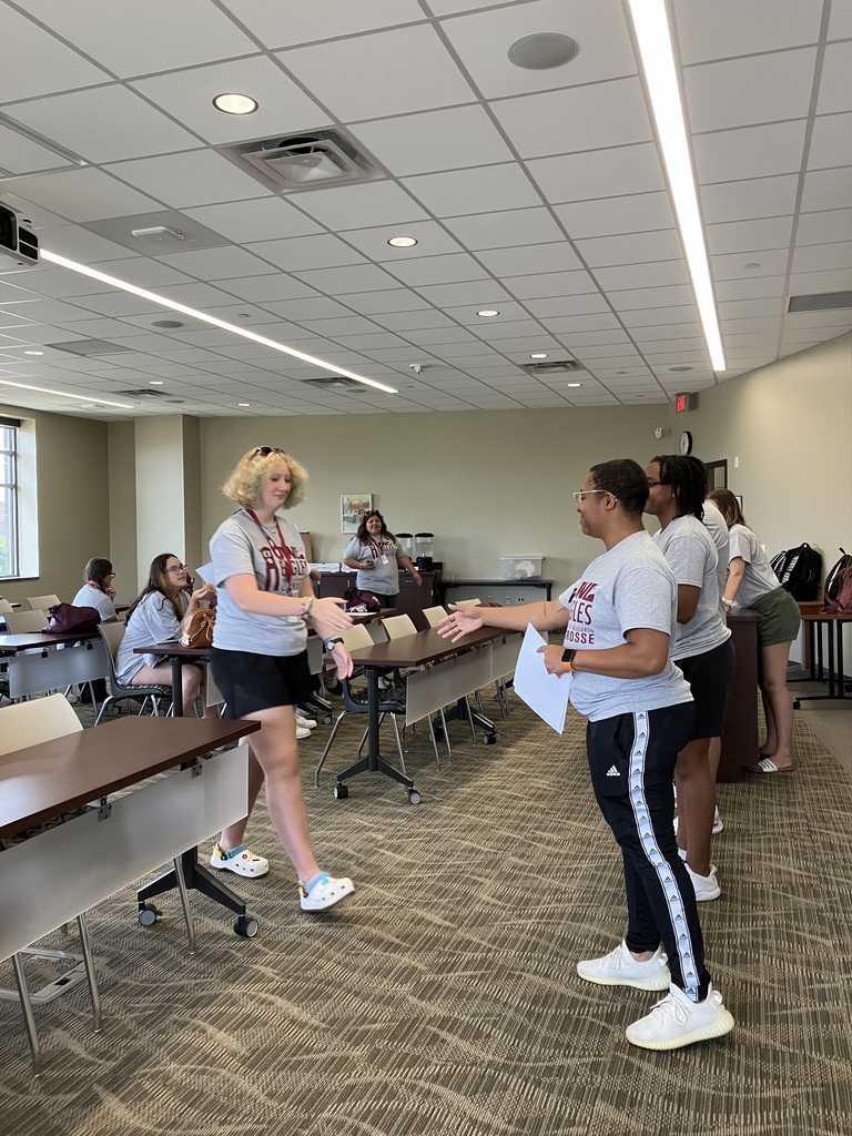 Student stepping forward to shake hands with university counselors.