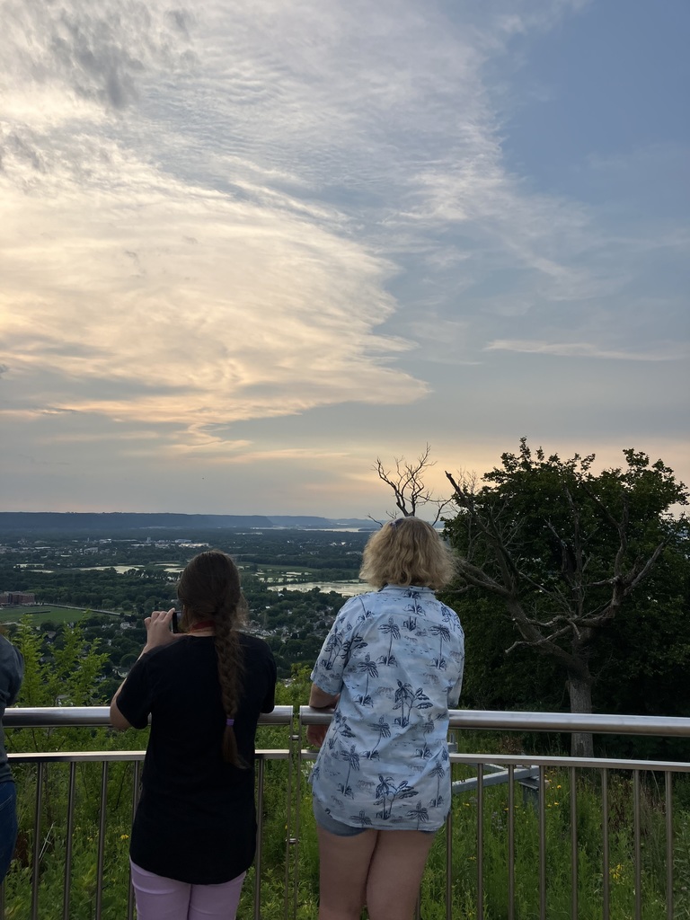 Two students looking at the land on a balcony.