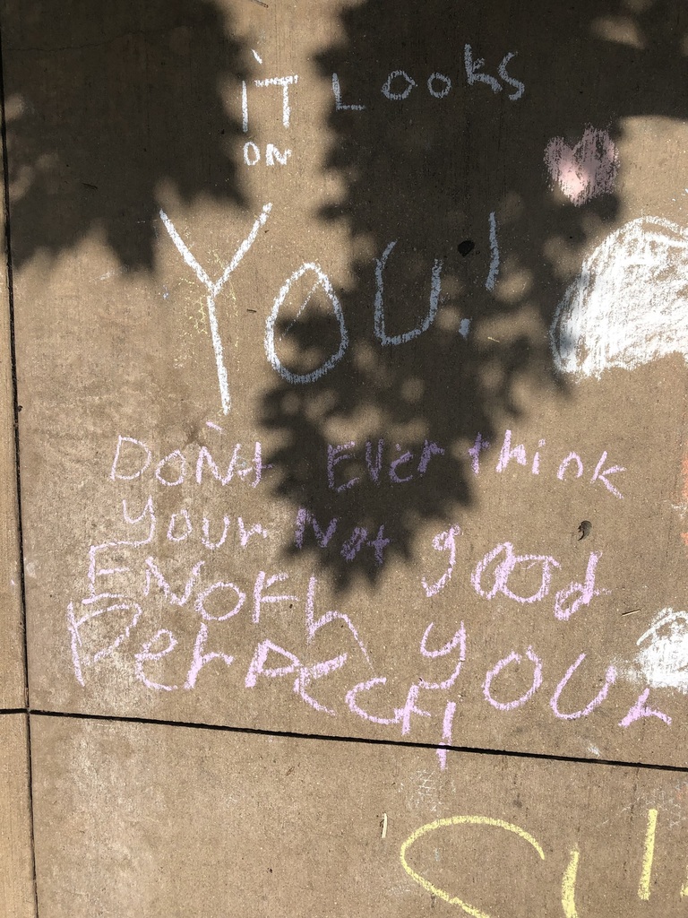 Inspirational words written in sidewalk chalk.