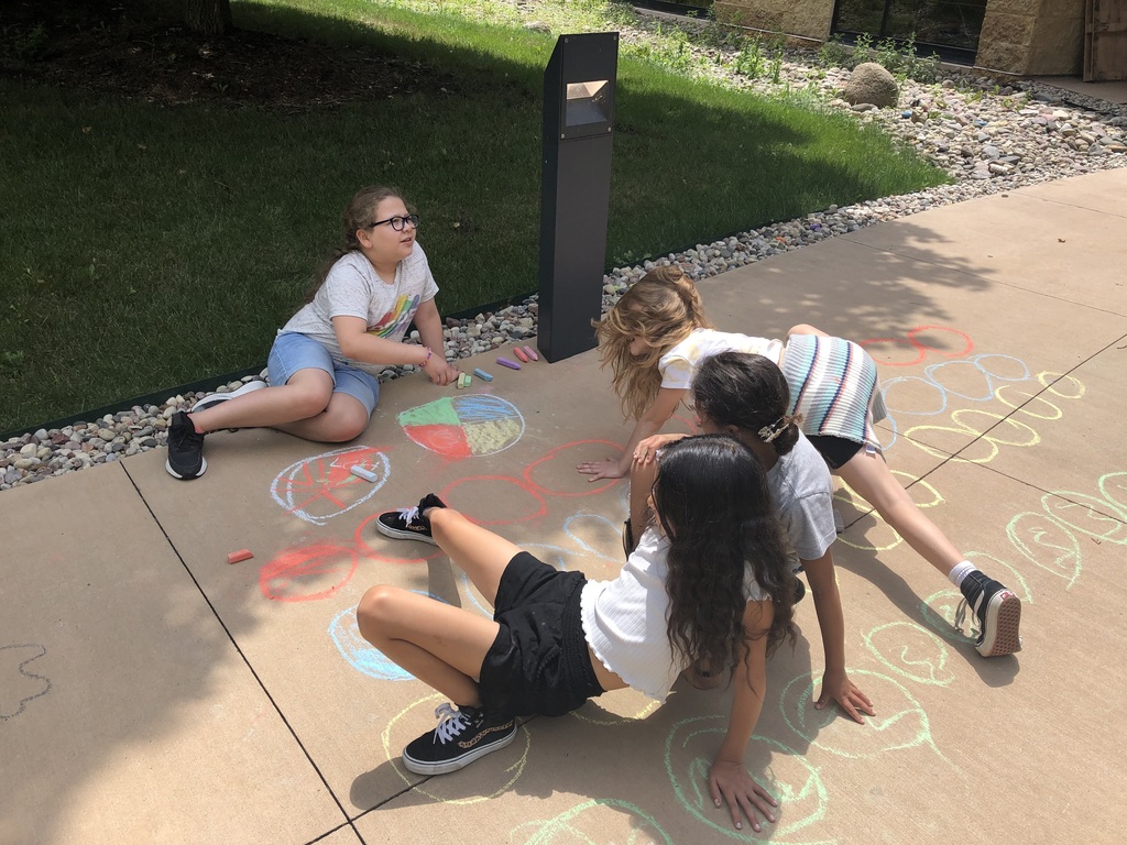 Four students playing sidewalk chalk twister.
