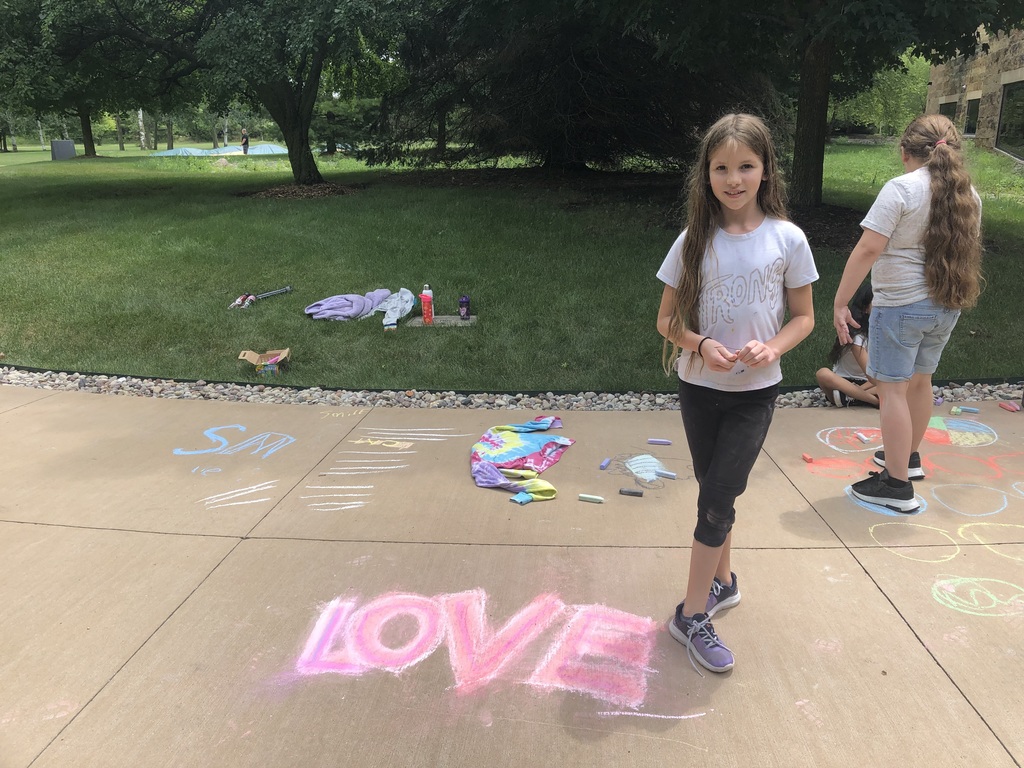 Girl posing with sidewalk chalk art.