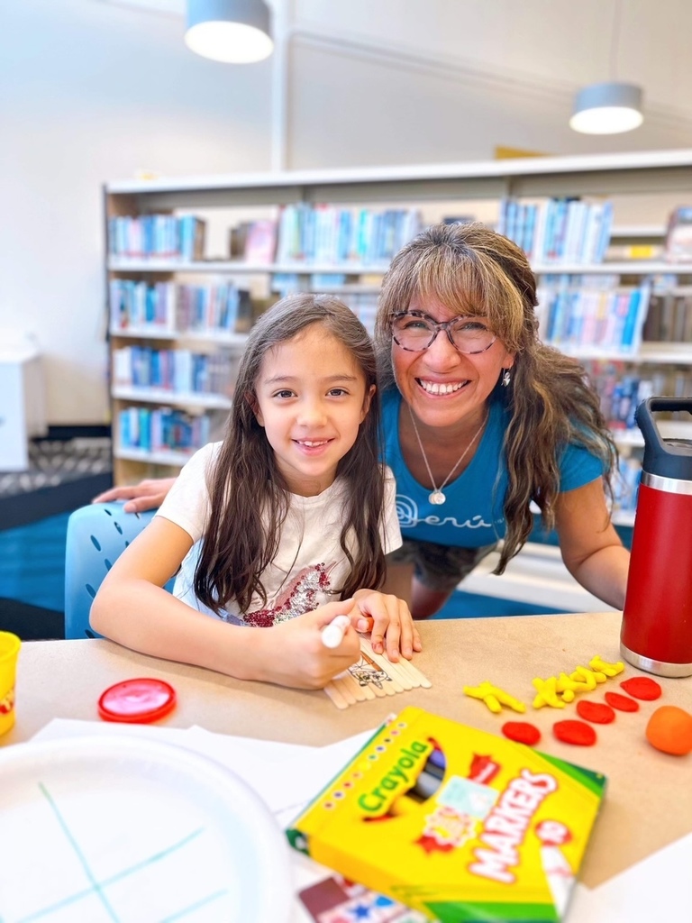 A woman and a girl work together on a craft project