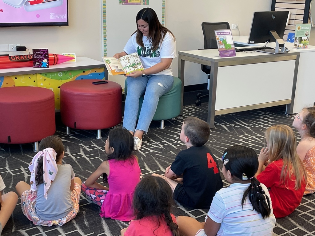 A Woodland teacher reads a story to a group of children
