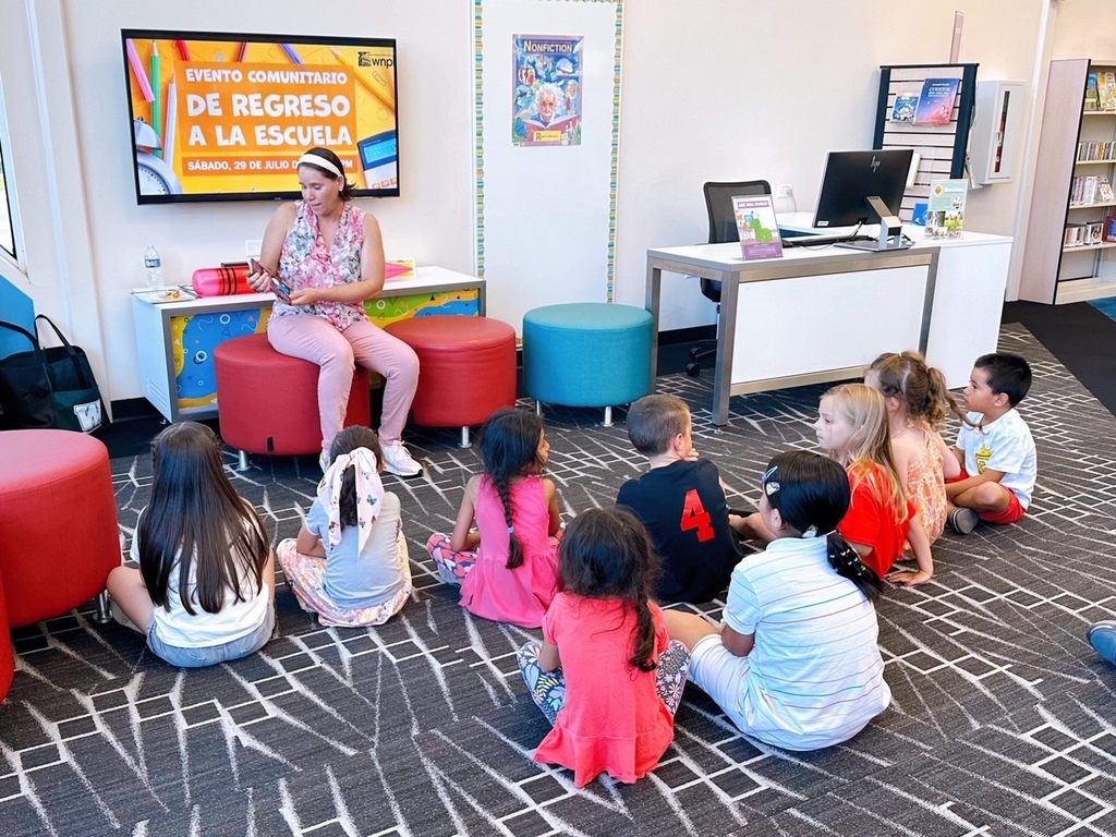 A Woodland teacher reads a story to a group of children