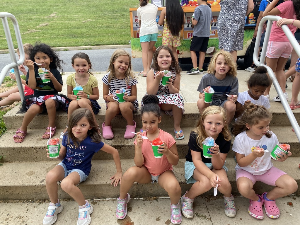 Students sitting on the steps enjoying Kona ice.