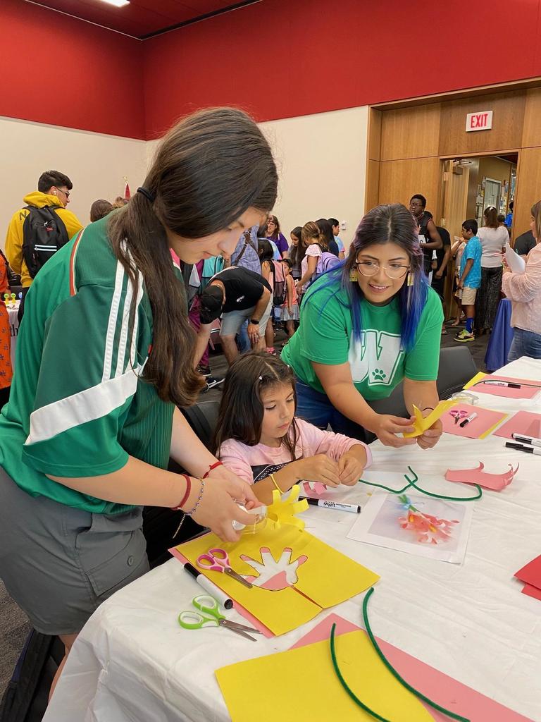 A teacher shows event attendees how to do a craft
