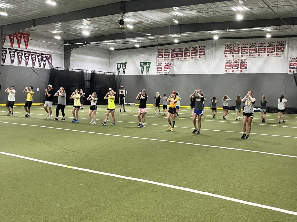 Students practicing marching band in the indoor facility
