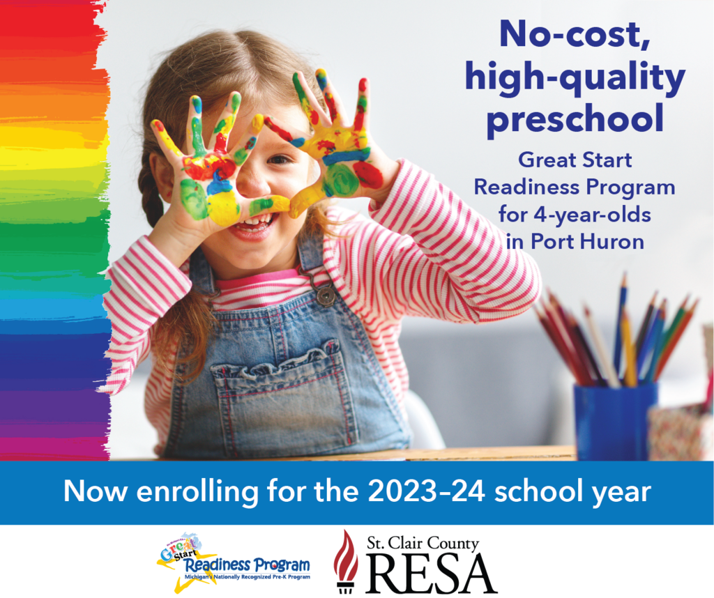 Student with paint on their hands showing them to the camera