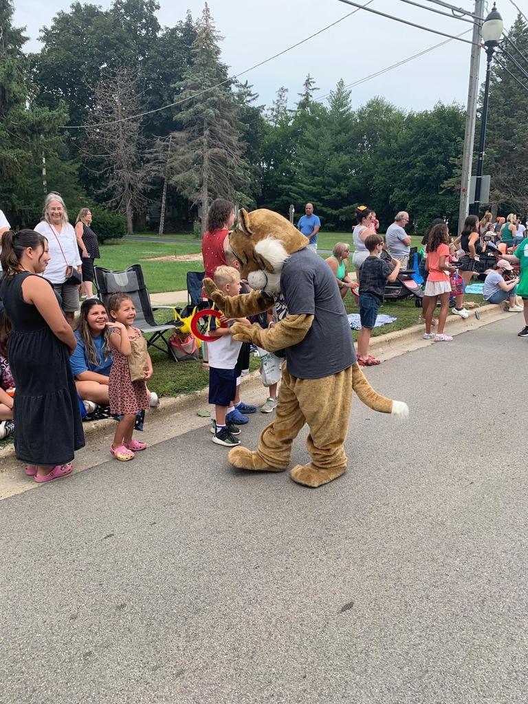 Wiley the Wildcat interacts with parade attendees