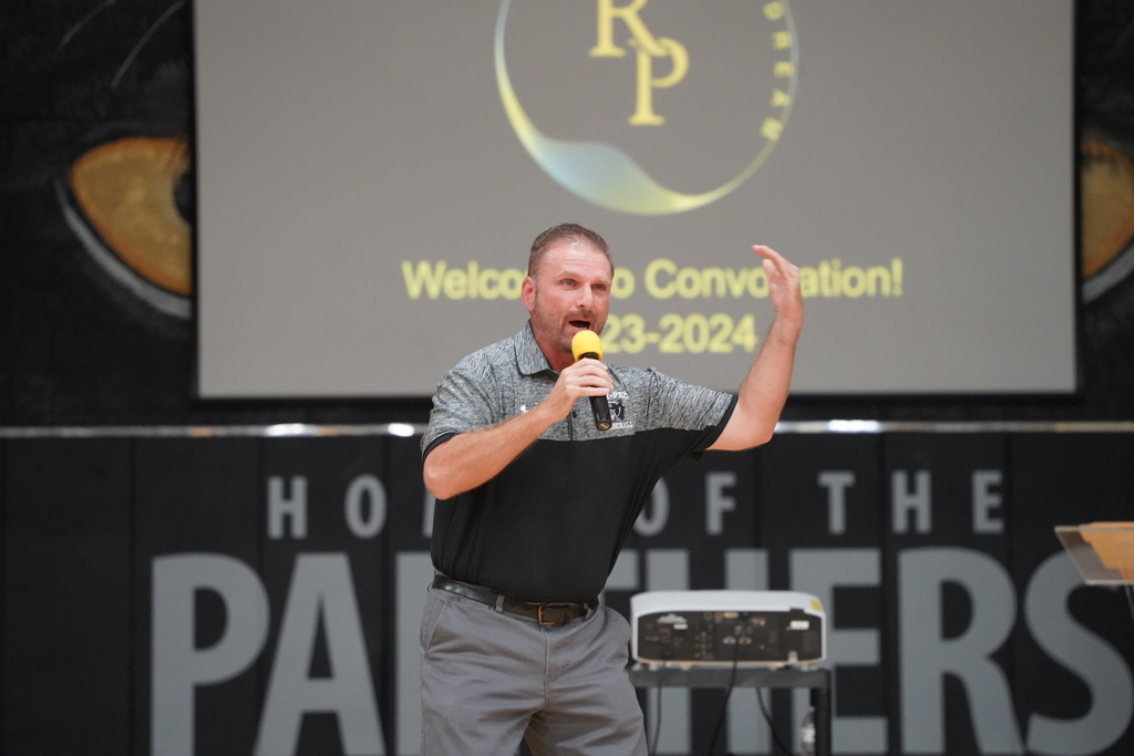 Teacher of the Year Brandon Ransom gets the crowd hyped up for convocation to begin