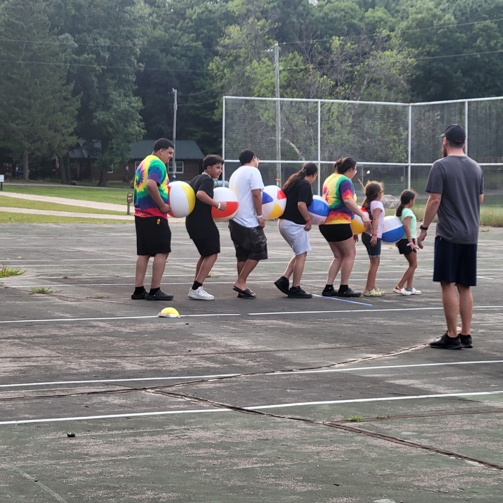 Line of 7 family members with beach balls between them.