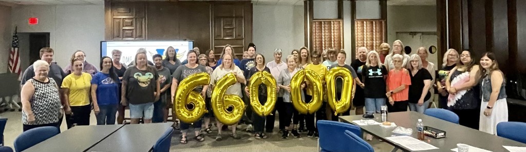 group of nutrition staff stand while holding numbers 66,000