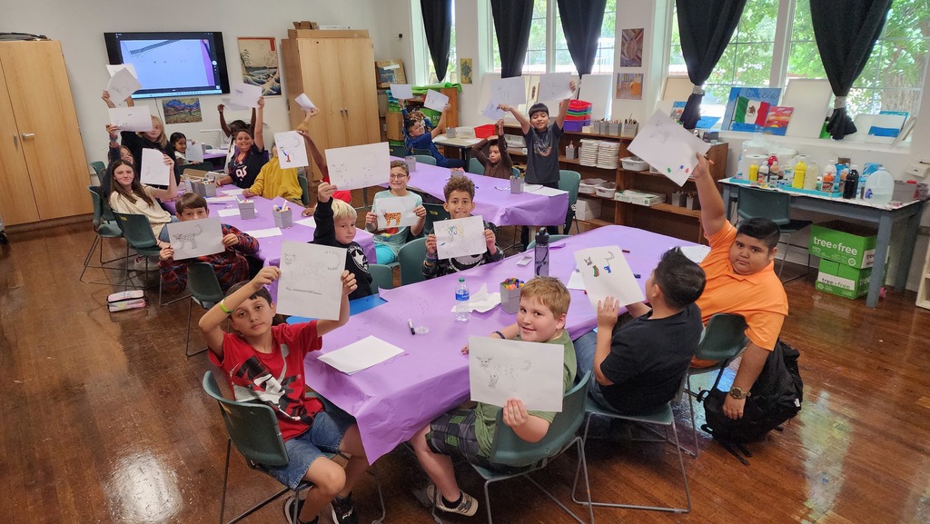 students displaying drawings