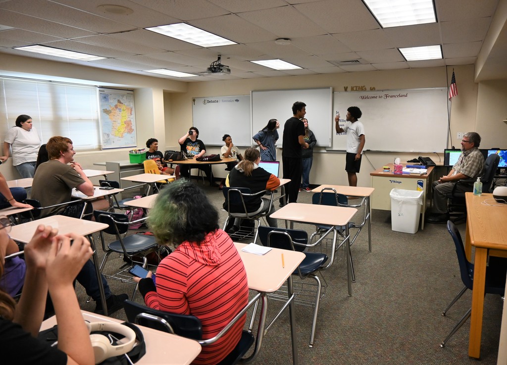 Four high school students  practice forensics skit in front of their class.