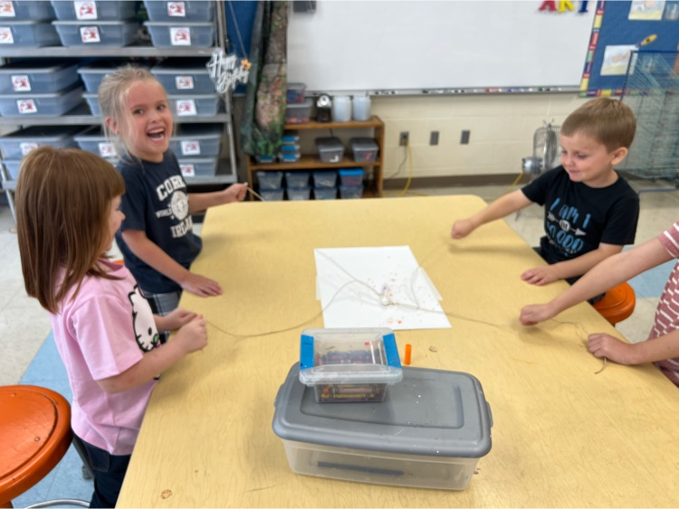During Exploratories today Kindergarten worked together to try to draw a smile with a marker. The catch? They could only move the marker using the string! Loads of laughs & communication practice! #HESRedHawks