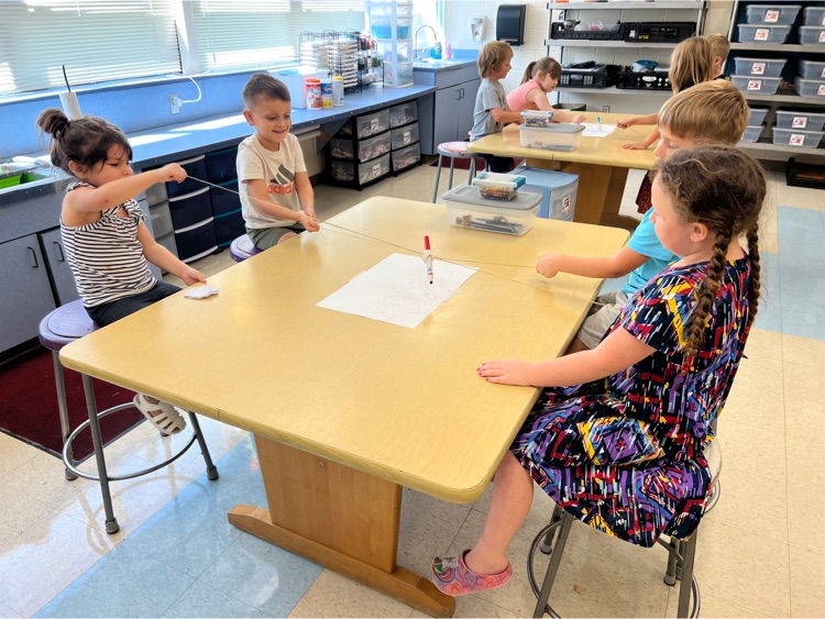 During Exploratories today Kindergarten worked together to try to draw a smile with a marker. The catch? They could only move the marker using the string! Loads of laughs & communication practice! #HESRedHawks