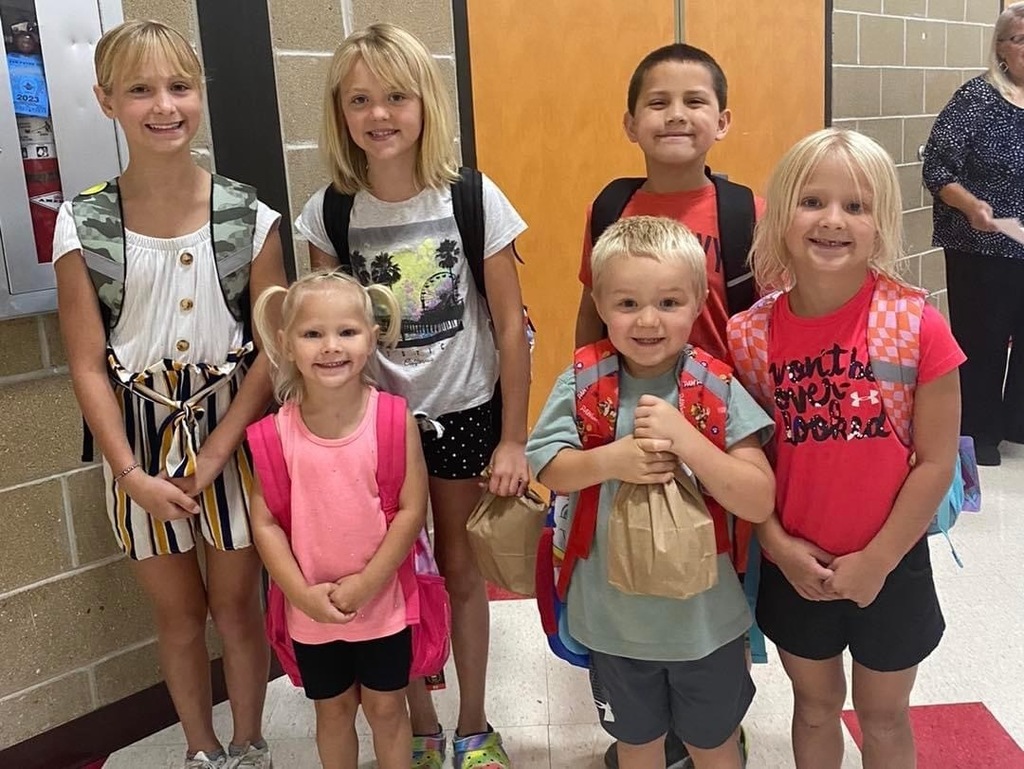Smiling students with their school supplies