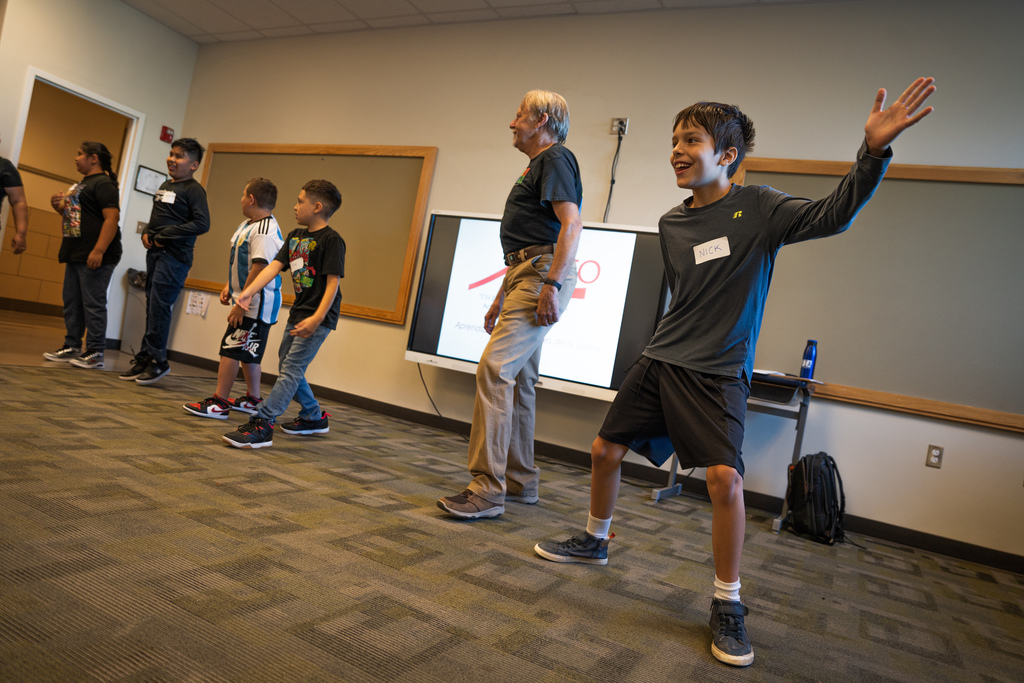 boy dancing next to a teacher and classmates