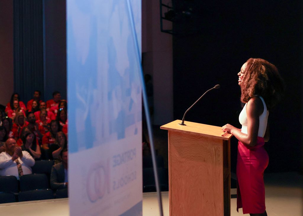 a young woman speaks at a podium in an auditorium