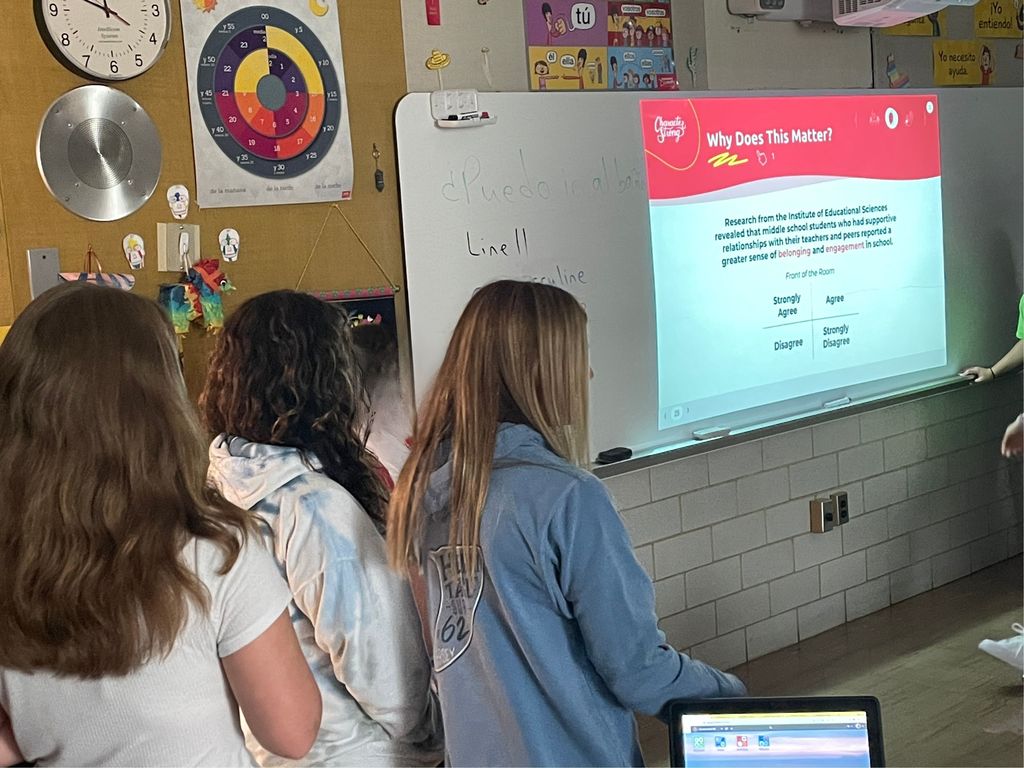 Three students standing to the left of an image reading "What Does This Matter?"
