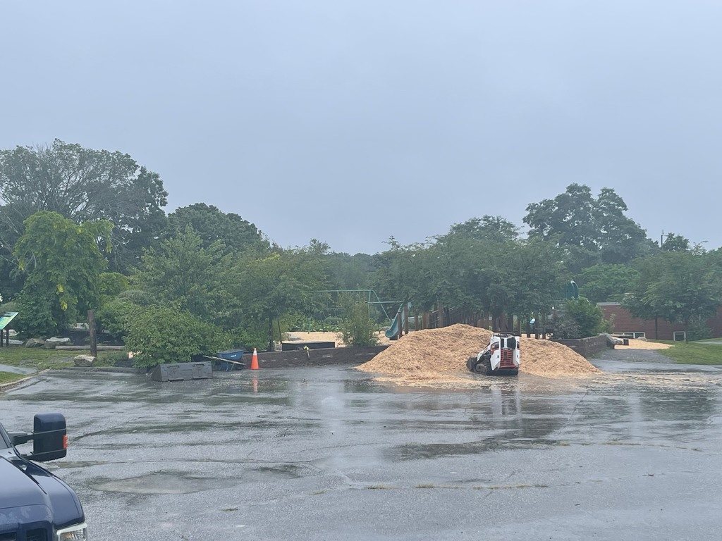 School playground getting new wood chips with a bulldozer
