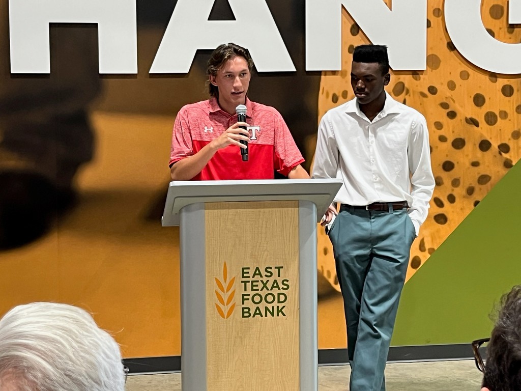 students speaking at podium