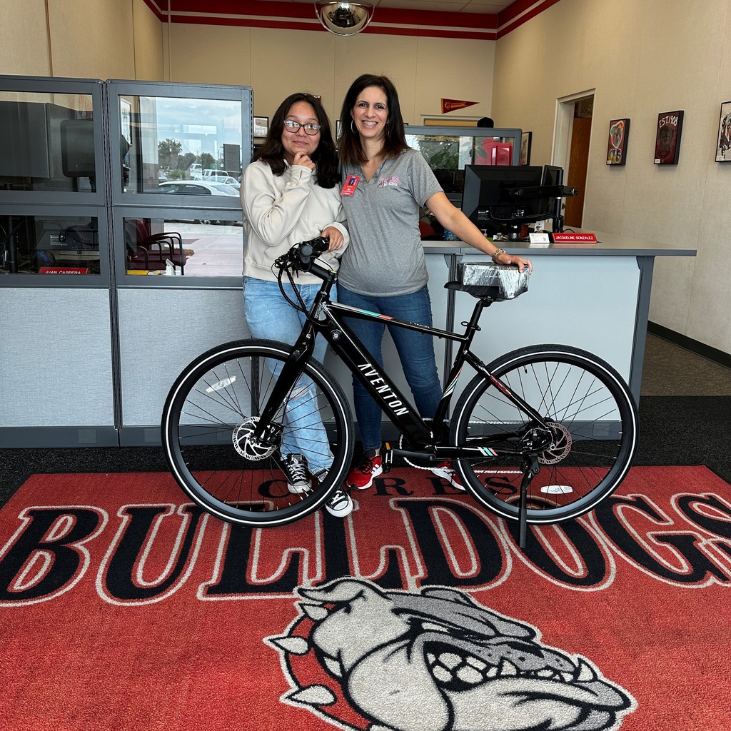 Principal in school office with student in front of bicycle