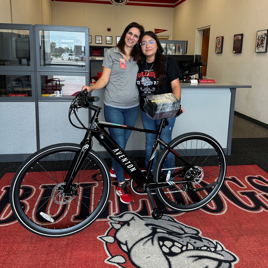 Principal in school office with student in front of bicycle