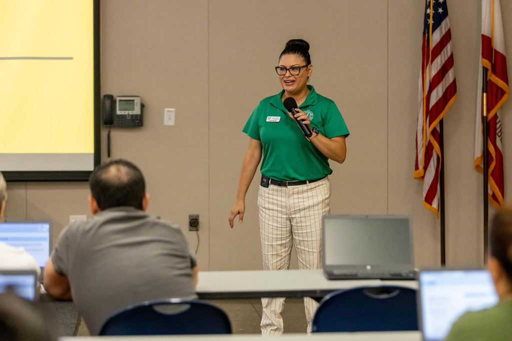 Edith Narayan holds microphone , addresses audience