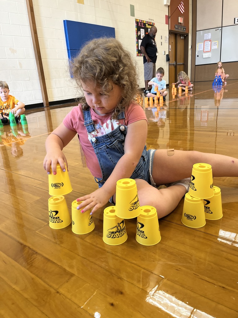 A student stacks cups in P.E. class.
