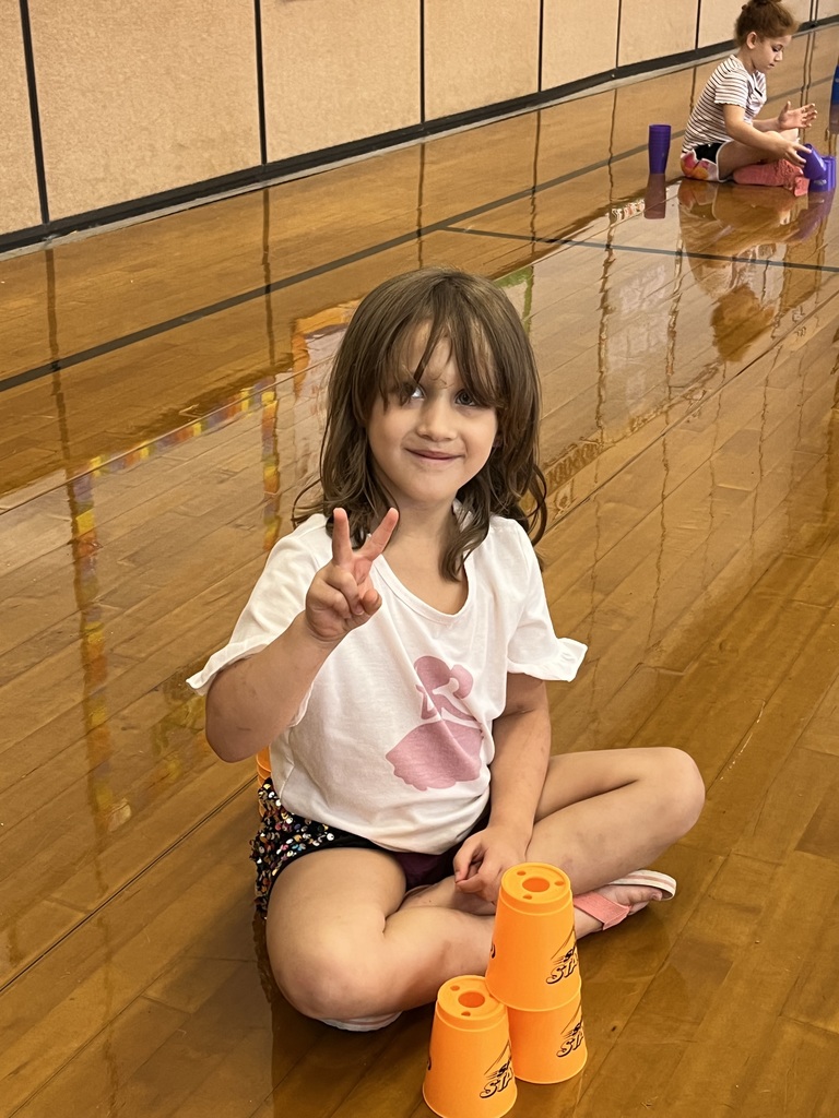 A student stacks cups in P.E. class.