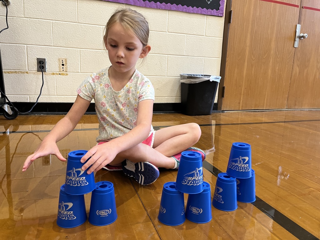 A student stacks cups in P.E. class.