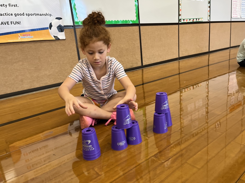 A student stacks cups in P.E. class.