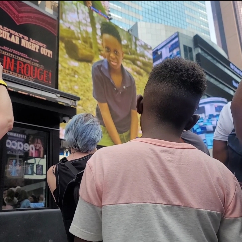 Ethan sees his photo displayed on a billboard in Times Square