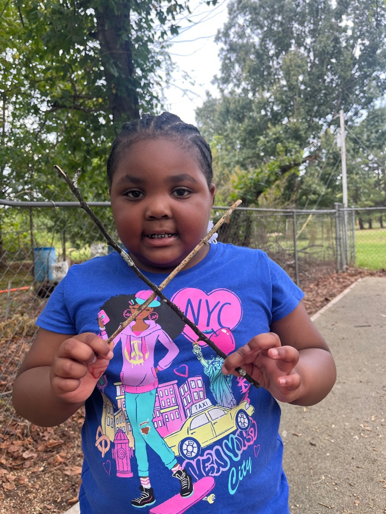 Harmony Grove Pre-K students use materials from nature to make letters while playing on the playground