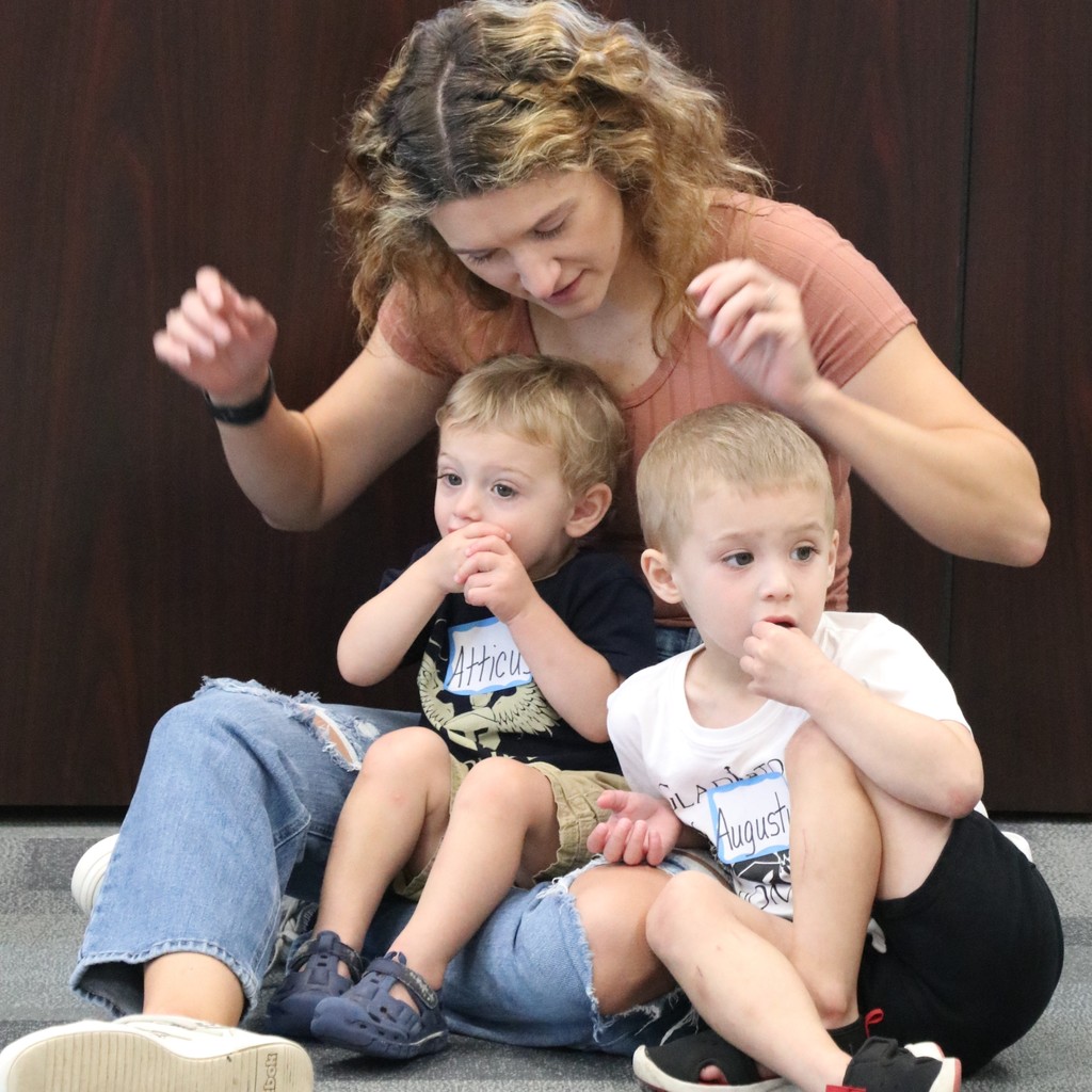 Two boys sitting on their mom's lap