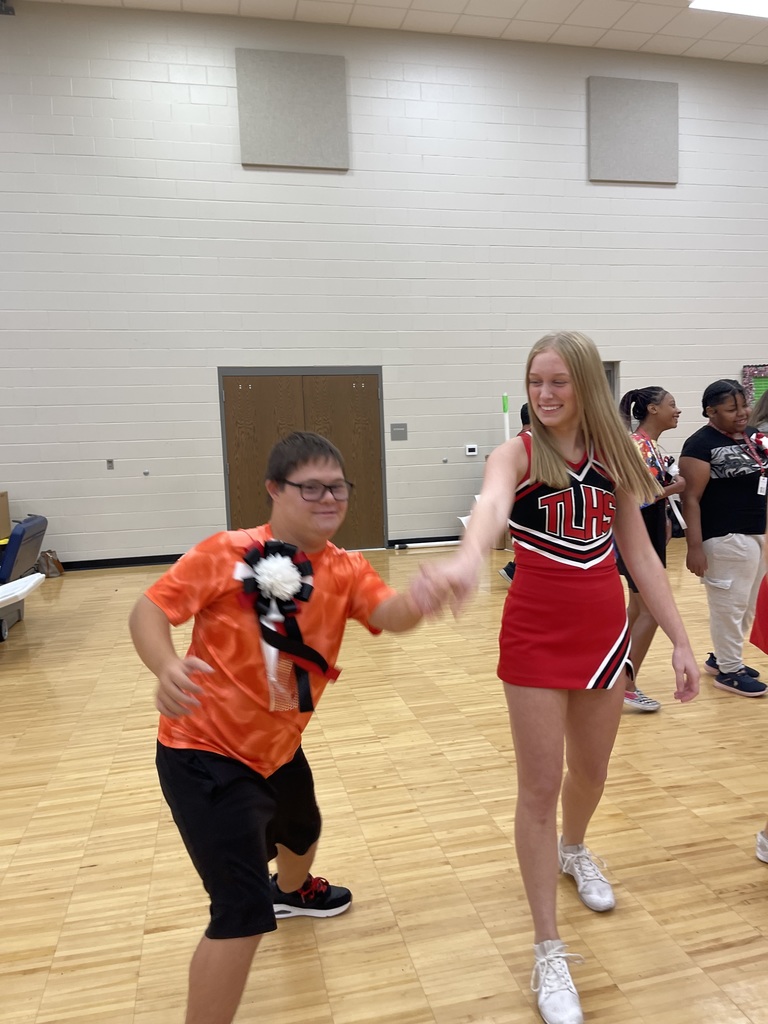 Legacy cheerleader dancing with student at homecoming