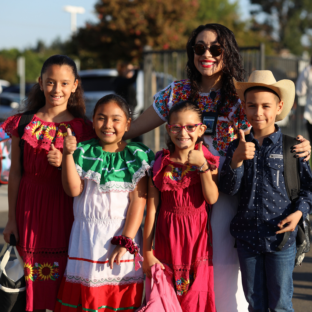 Ms. Marshall with four students in traditional outfits