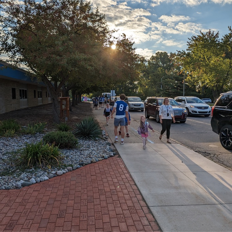 football players greeting students at drop off