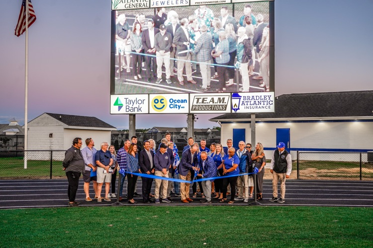 ribbon cutting in front of video board