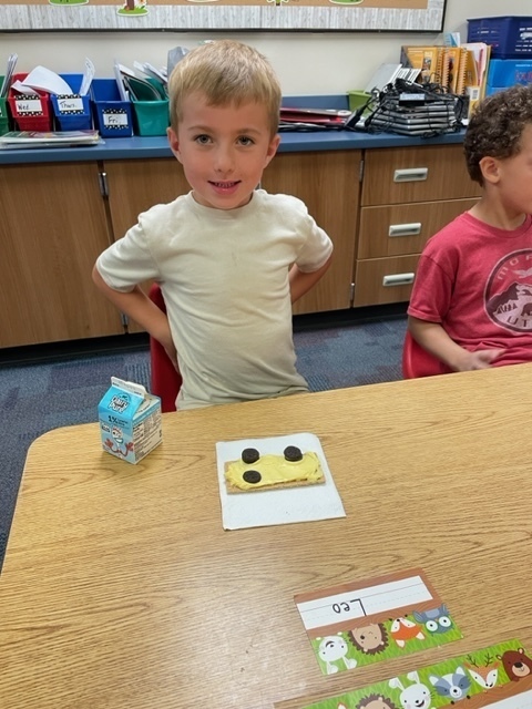 student sitting with milk and a yello cookie