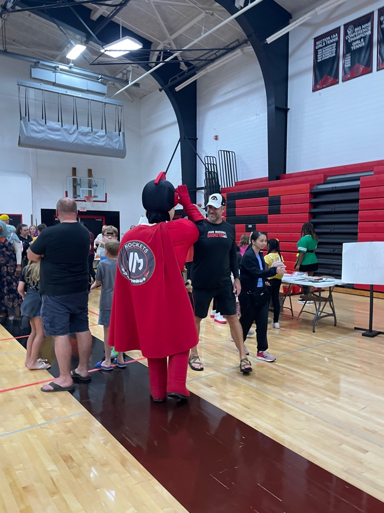 Rocket man (JM mascot) gives Principal Ruzek a high five 