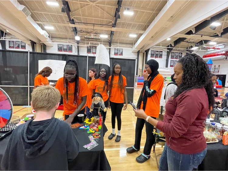 FCCLA students stand by their table in the gym