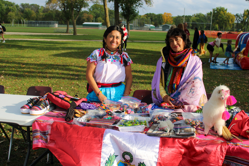 Two vendors posing behind their table of custom made goods.