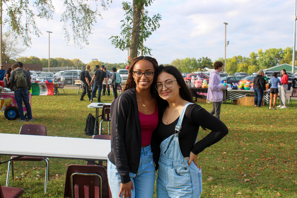 Two students posing in front of one of the dining tables at the Hispanic Heritage event