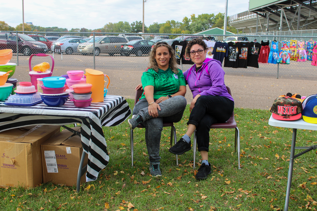 Two vendors posing together between their tables.