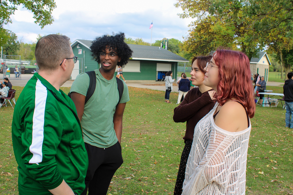 Students engaging with a teacher at the Hispanic Heritage Event.